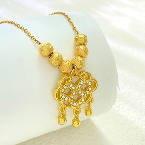 Macro detail of a gold-toned hollow lock pendant with sparkling micro-pave crystals