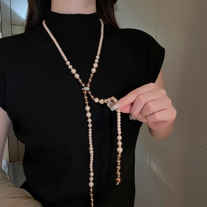 Detail of multi-color pearl long necklace with rhinestone buckle on elegant model