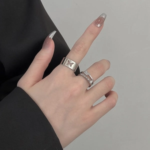 Detail of hand wearing silver bow knot zircon ring and镂空 butterfly ring set
