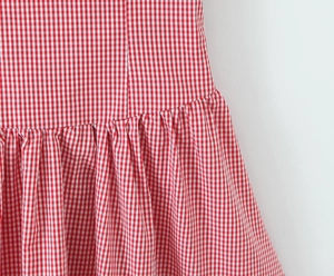 Détail de la robe à carreaux rouges et blancs avec couture à la taille et plis