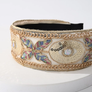 Detail of high crown headband featuring floral embroidery with sequins and rhinestones