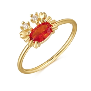 Macro shot of 18K gold crab ring featuring an orange gemstone and sparkling crystal eyes