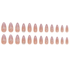 Almond press-on nails with pink gradient, white bows, and elegant pearl accents