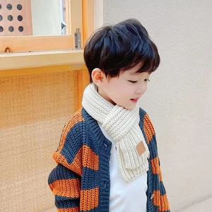 Kids beige knitted scarf with vintage leather patch paired with a striped cardigan