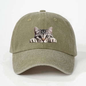 Close-up of olive green baseball cap featuring a detailed tabby cat graphic and twill texture