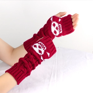 Detail of dark red knit arm warmer with skull pattern and cable knit texture