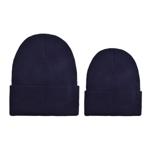 Detail view of two navy blue knitted beanies in adult and child sizes on white background