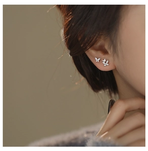 Macro detail of silver double butterfly stud earrings with sparkling cubic zirconia stones