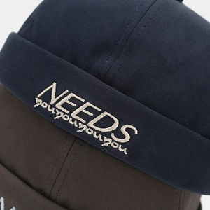 Detail of high-density cotton miki hat featuring precise NEEDS embroidery on the brim