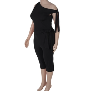 Detail of one-shoulder jumpsuit with waist tie knot and slim fit cut in black