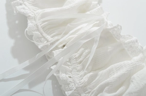 Gros plan détaillé sur la texture du tissu blanc avec dentelle et rubans décoratifs