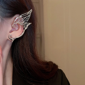 Detailed view of silver butterfly wing ear cuff with hollow carved texture on model