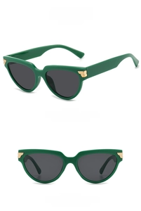 Dettaglio occhiali da sole cat-eye verdi con dettagli in metallo dorato e lenti grigie