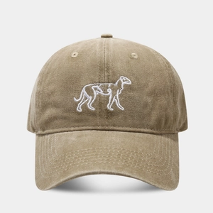 Dettaglio di un cappello vintage kaki con ricamo bianco di un levriero sagomato