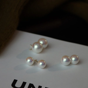 Macro shot of three pairs of 925 silver pearl stud earrings with aurora luster