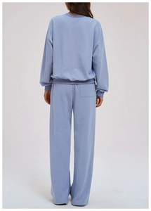 Back view of woman wearing a blue-purple tracksuit with hoodie and matching joggers