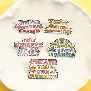 Five-piece inspirational enamel pin set with positive quotes on white ceramic dish