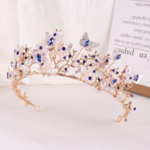 Detail view of a gold bridal crown with blue crystals and elegant white flower accents