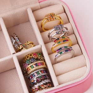 Detailed top view of assorted 18K gold and silver plated cubic zirconia rings in a pink velvet box