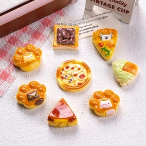 Flat lay of assorted resin miniature food charms including waffle and cake slices