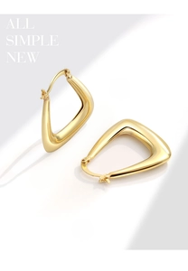 Close-up of golden geometric U-shaped hoop earrings with a polished hollow metal finish