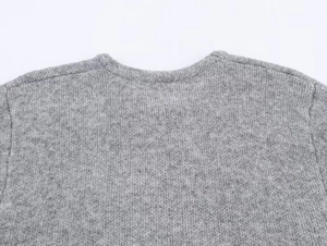 Detailed close-up of the knitted collar and shoulder seam on this gray wool cardigan