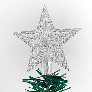 Detailed view of a silver filigree glitter star topper on a green Christmas tree
