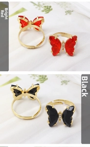 Detail of crystal butterfly ring set in red and black with adjustable gold bands