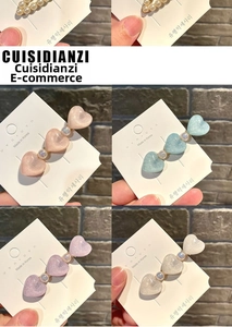 Detailed macro view of heart-shaped resin hair clips with pearls in four pastel colors