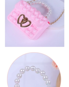 Detail of pink silicone heart pop bag featuring faux pearl handle and metal clasp