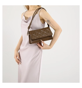 Détail d'un sac à bandoulière matelassé marron avec motifs géométriques 3D et bandoulière nouée