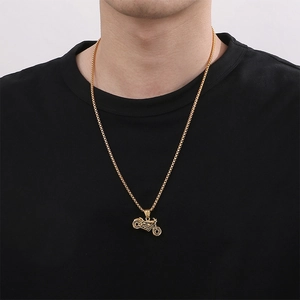 Golden motorcycle pendant on a stainless steel chain worn by a male model on a black shirt