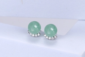 Detailed macro view of S925 silver stud earrings with green jadeite and sparkling zircons