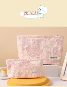 Detail of two-piece pink floral jacquard cosmetic bags with silver zipper and brand label