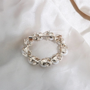 Macro shot of the gold alloy back and secure metal pin buckle of the pearl wreath brooch