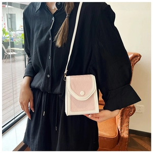 Détail d'un sac à bandoulière matelassé en cuir PU blanc et rose porté par un mannequin