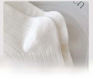 Close-up of reinforced heel and ribbed texture on white cotton mid-calf socks