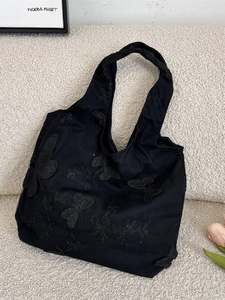 Black canvas tote bag with 3D butterfly embroidery and wide handles for shoulder use