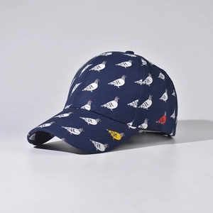 Detailed view of navy blue baseball cap with designer pigeon prints and curved brim