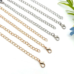 Close-up of gold and silver extender chains with lobster clasps for jewelry making