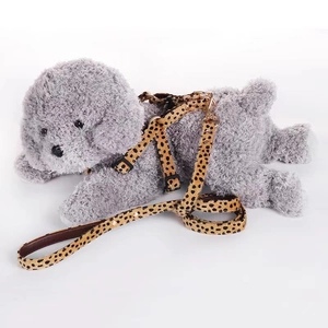 Detail of leopard print pet harness and leash set with gold hardware on a model