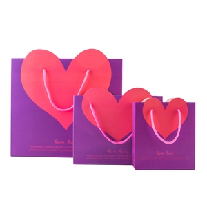 Three sizes of purple paper gift bags featuring pink hearts and woven rope handles