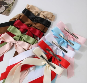 Detail of satin double-layered bow hair clips with metal alligator grip and vibrant colors