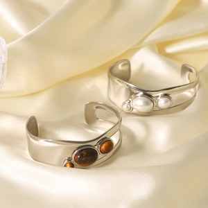 Detailed side view of silver open cuff bangle with pearl and brown tiger eye stone