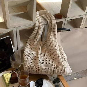 Detail of beige hollow knit tote bag showing intricate crochet patterns and woven texture
