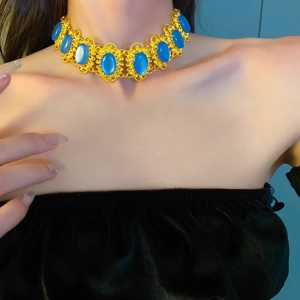 Detail view of a vintage oval geometric choker with gold finish and blue stones