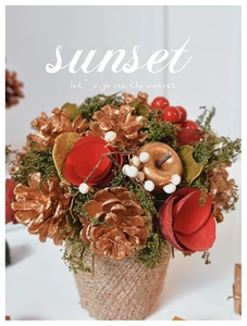 Close-up of golden pine cones and red dried flowers in a burlap pot for holiday decor