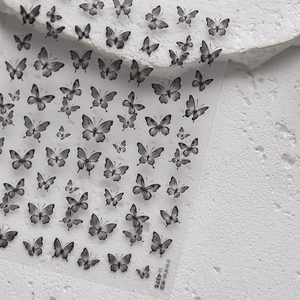 Dettagli macro di adesivi per unghie con farfalle in bianco e nero e inchiostro