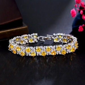 Macro detail of yellow zircon bracelet with round cut stones on silver setting