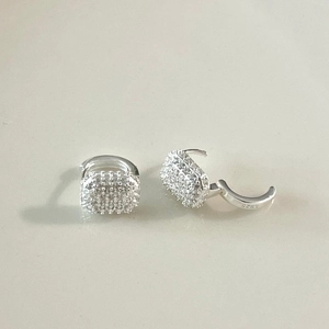 Macro view showing the S925 hallmark on silver hoop earrings with pave-set zircons
